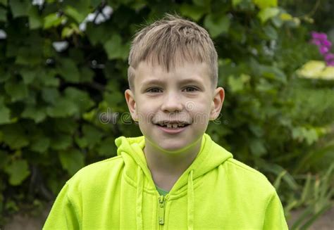 Street Portrait Of A Smiling Boy 10 Years Old Against The Background Of