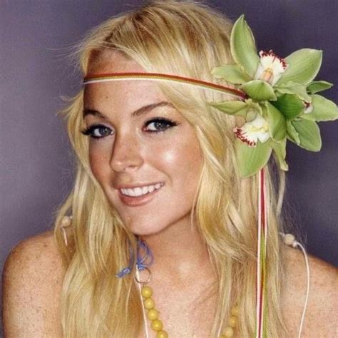 A Woman With Long Blonde Hair Wearing A Flower In Her Hair And Beads Around Her Neck