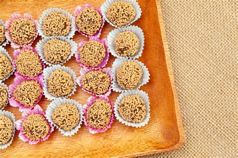traditional homemade sweets known in brazil as brigadeiro de amendoim on a wooden tray isolated