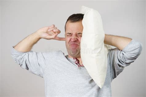 Sleepy Man With Pillow Closing His Ear Stock Photo Image Of
