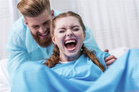 Pregnant Woman Giving Birth In Hospital While Man Hugging Her Stock Photo Dissolve