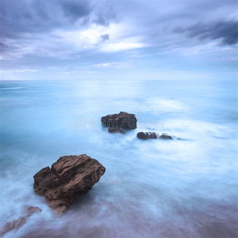 Rocks In A Ocean Waves Under Cloudy Sky Bad Weather Stock Photo