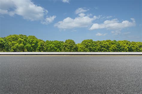 Asphalt Road And Green Trees Under Blue Sky Stock Photo Download