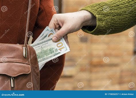 steal money from handbag woman fashion cloth and male hand with dollars cash concept street