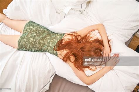 Back View Of Redheaded Woman Lying On Bed Photo Getty Images