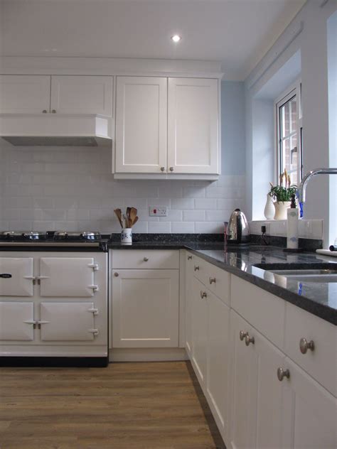 Dark blue kitchen cabinets with white countertops. Bespoke kitchen finished in Satin White with Blue Pearl ...