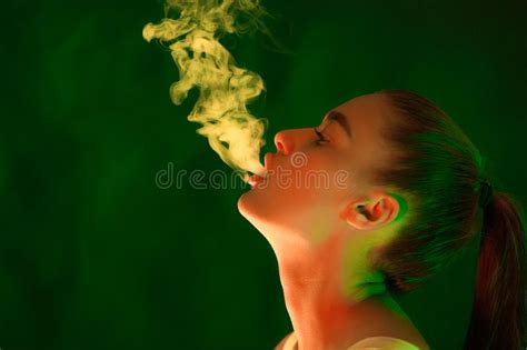 Smoking Girl Woman In Green Lights With White Smoke Stock Image