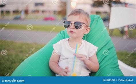 Cute Baby Boy In A Big Funny Sunglasses Sitting In Bean Bag Chair At