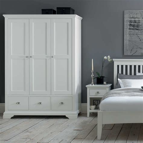 The cabinet is framed with a light wood color with a black lacquer. The Carrington White Triple Wardrobe - White Bedroom Furniture