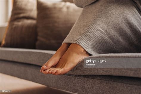 Closeup Of Womans Feet Sitting On Couch Photo Getty Images