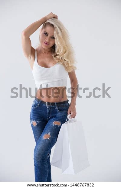 Sexy Blonde Shopping A Seductive Blonde Model Girl In Jeans And A White Shirt The Blonde Holds