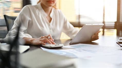 Female Accountant Using A Calculator Checking And Calculating A Sales