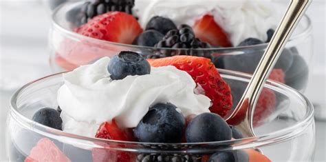 Close Up Of Glass Dishes Of Mixed Berries Topped With Creamy Whipping Cream Stock Image Image