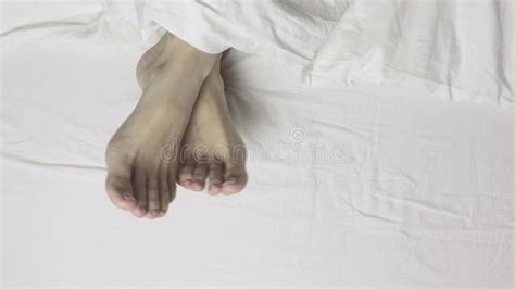 woman legs feet lying in bed top view morning waking up and relaxing stock footage video of