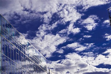 Beautiful Glass Office Building Reflecting Blue Sky And White Clouds