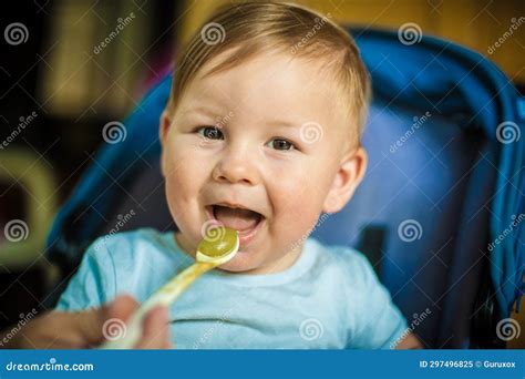 Beautiful Happy Baby Boy Eating Porridge Food With A Spoon Stock Image