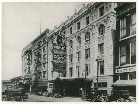 An Old Black And White Photo Of A Building With Cars Parked On The