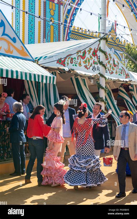 spanish women with colorful flamenco dresses casetas marquees feria de abril sevilla