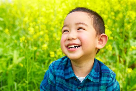 Happy Little Chinese Kid Playing In Spring Field By Stocksy