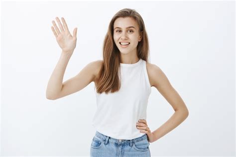 Free Photo Friendly Blond Girl Smiling And Waving Hand To Say Hi