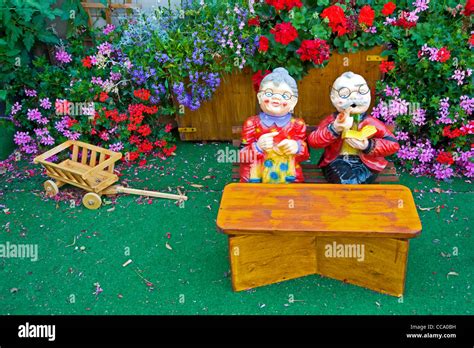 Two Toys Figurines In Miniature Garden Man And Woman Reading Netting