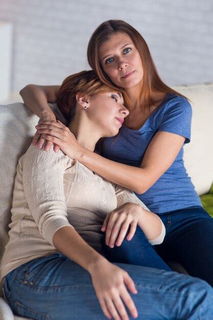 Pareja homosexual de mujeres lesbianas en casa en el sofá abrazándose y disfrutando Foto Premium
