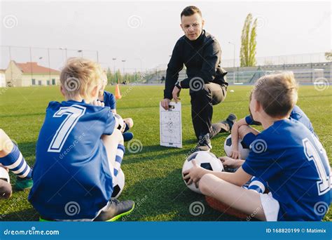 Young Coach Explaining Soccer Positions And Match Tactics To Youth