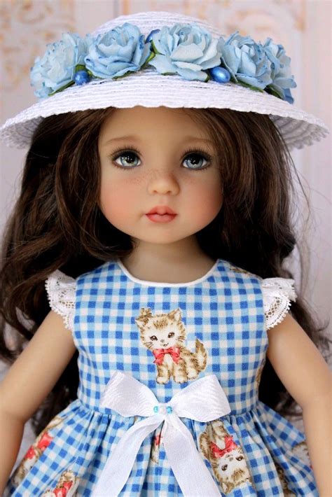 A Doll Wearing A Blue Dress And White Hat