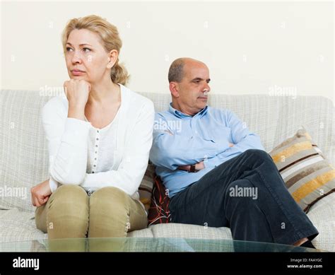 Angry Mature Married Couple Having Quarrel At Living Room Stock Photo