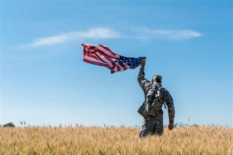 View Of Soldier In Military Uniform Standing In Field With Golden Wheat