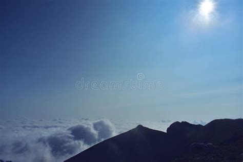 Fluffy White Clouds Among The Mountain Ridges Mist At High Altitude