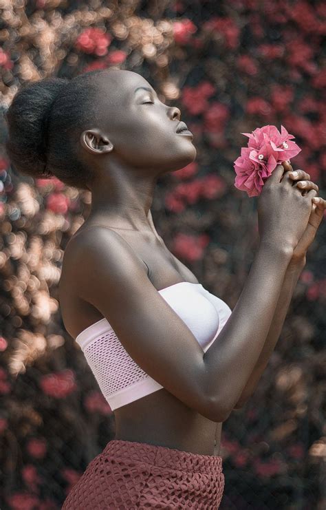 Download African Woman Holding A Pink Flower Wallpaper Wallpapers Com