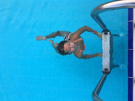 Girl In The Pool Underwater With Her Face Directed Towards The Sun