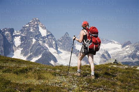 A Female Hiker Hikes A Trail In The Selkirk Mountains With A View Of