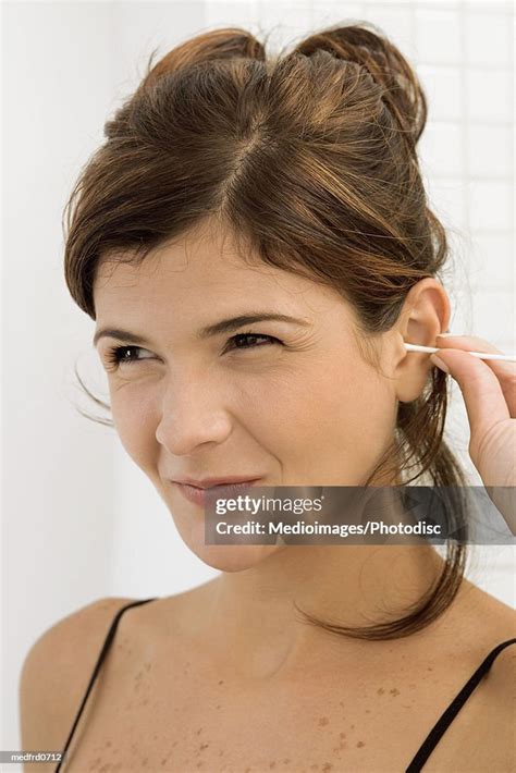 Young Woman Cleaning Her Ear With A Cotton Swab High Res Stock Photo