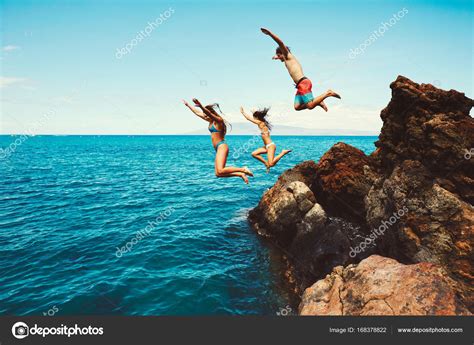 Friends Cliff Jumping Into The Ocean — Stock Photo © Epicstockmedia
