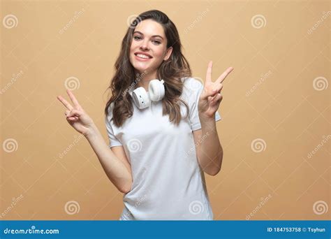 Lovely Young Woman Showing Victory Or Peace Sign Isolated Over Beige