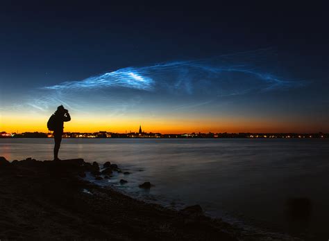 Green grass field under white clouds and blue sky during daytime. Electrifying noctilucent clouds over Denmark in photo and ...