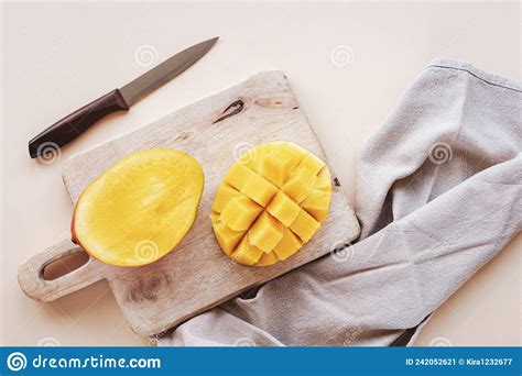 Halves Of Mango On A Cutting Board On Beige Backgrownd Top View Flat