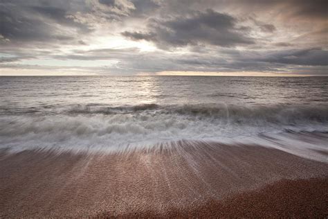 Waves Crashing Over The Beach At Burton Photograph By Julian Elliott