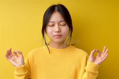 Calm Asian Woman Makes Zen Nirvana Gesture Meditates With Closed Eyes