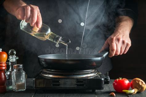 The Chef Or Cook Adds Olive Oil To The Pan While Cooking Working
