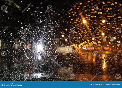 Rain Drops On Glass Of Car Window With Street Bokeh At Night In Rainy