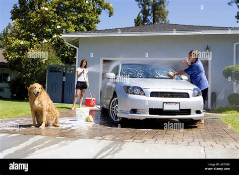 Teenagers washing car in driveway Stock Photo - Alamy