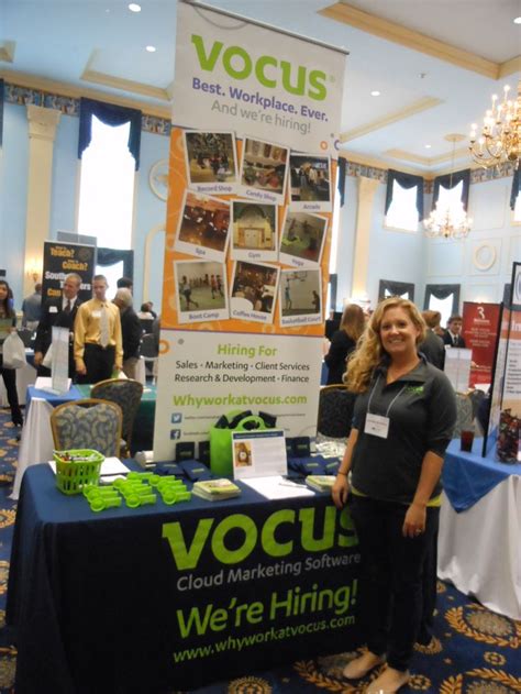 A Woman Standing In Front Of A Table With A Sign That Says Vocus On It