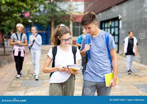 Students Holding Bags And Talking While Walking Stock Photo Image Of