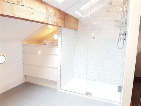 Sloped ceilings in the closet: Attic bathroom by Ultimate Wetrooms. White subway tiles ...