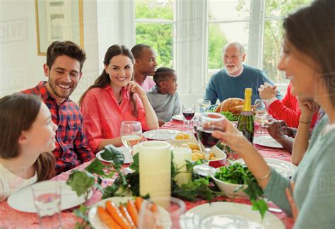 Try a couple of recipes from this lineup of kids meal ideas and ring that dinner bell, delicious is served! Multi-ethnic multi-generation family enjoying Christmas dinner at table - Stock Photo - Dissolve
