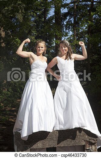 Just Married Happy Lesbian Couple In White Dress Close Together In Forest On Concrete Pedestall