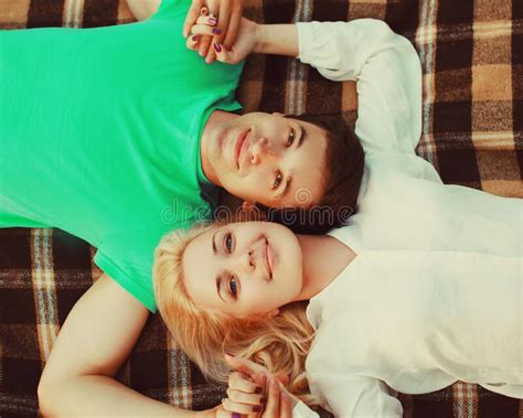 Portrait Of Happy Loving Young Couple Lying Together On Plaid In The